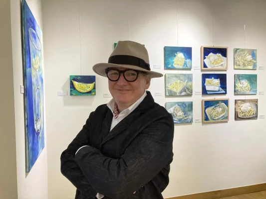 Le peintre Hans-Eberhard Stein au cœur de son exposition 'Frittenfantasie' au Micro Musée de la Frite de Home Frit' Home (photo Rita Madou). Hans-Stein_Frittenfantasie_Home-Frit-Home_WEBP